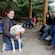 A guide petting a sled dog while giving a presentation to a group of Guests